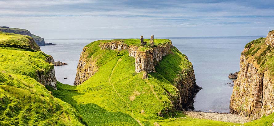 A view of green grass topped cliff tops. looking out onto the Irish sea.