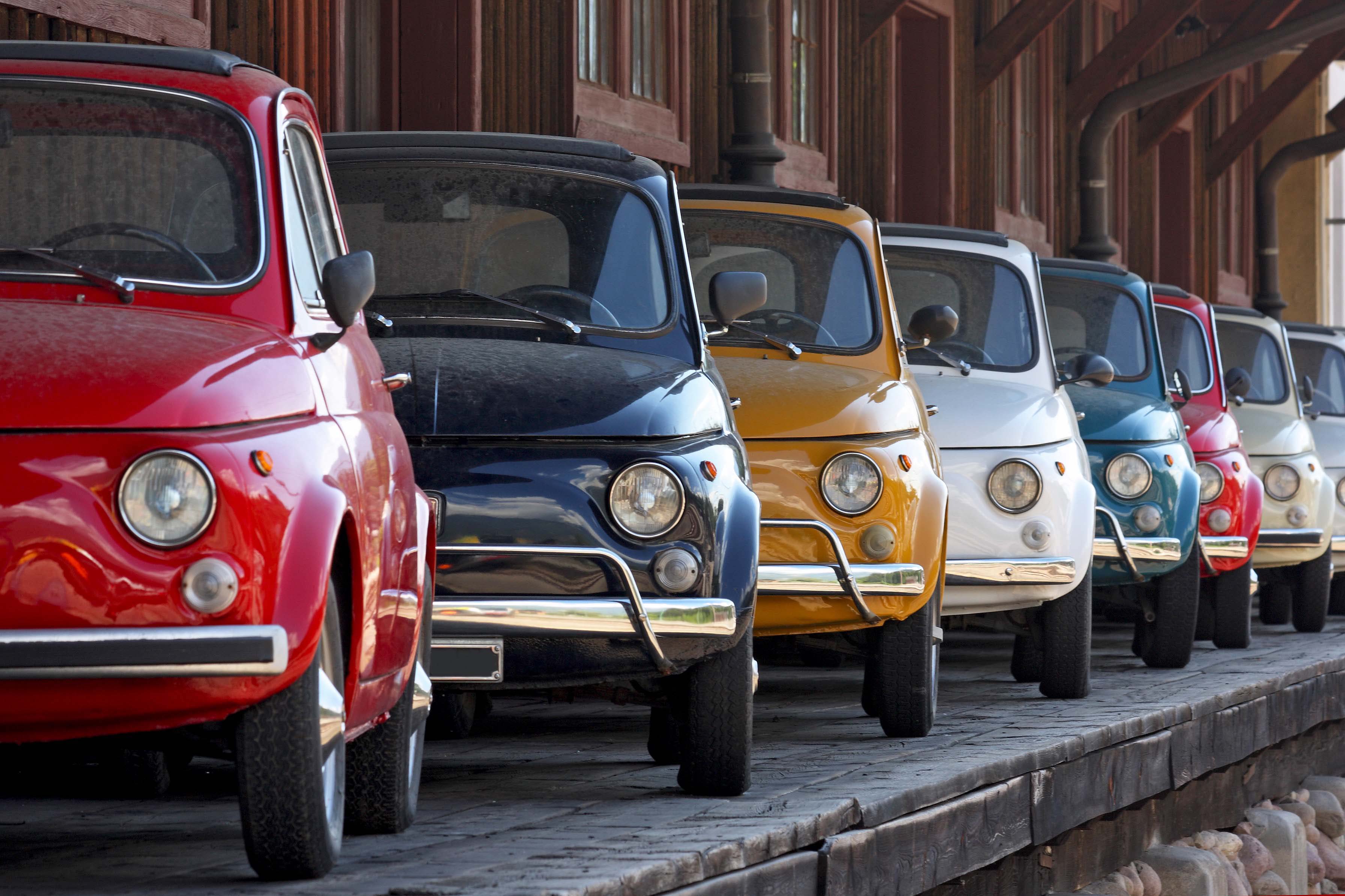 Row of coloured vintage italian cars (Fiat 500 and 600). They are compact and popular Italian cars produced in the sixties and seventies.