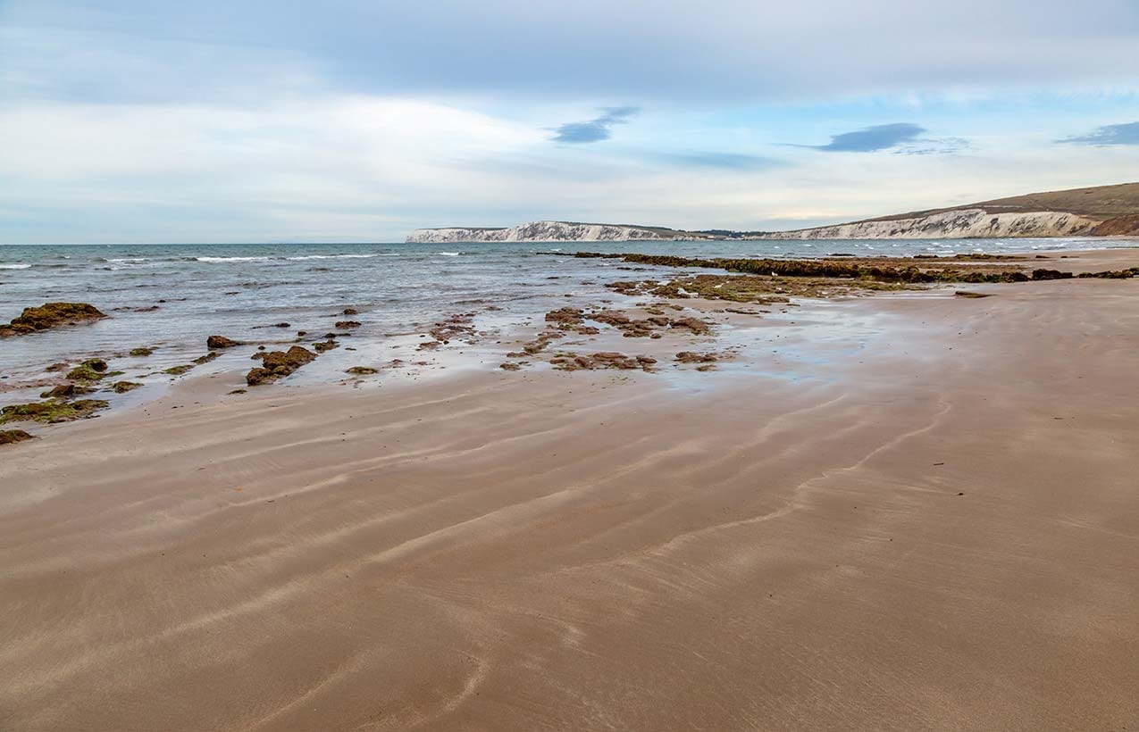 Picture of the beach on the Isle of Wight. White cliffs can be seen in the distance.