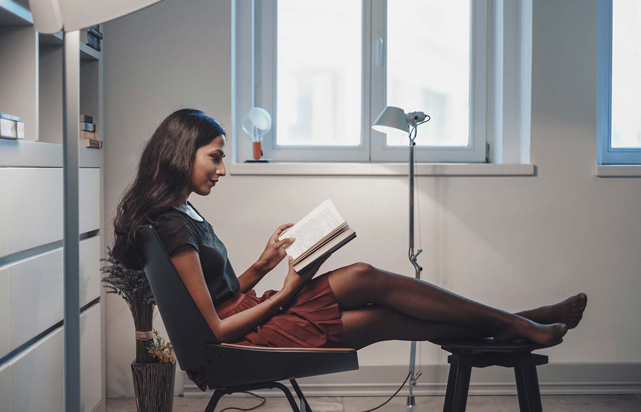 Woman reading a book in her home