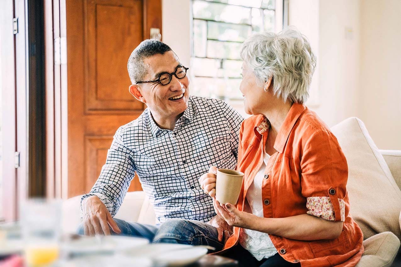 Smiling happy Asian Senior Couple drinking coffee