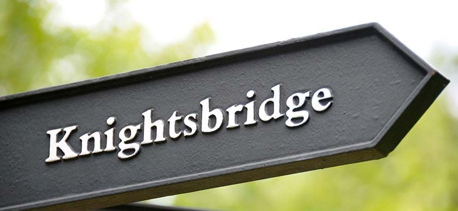 Arrow shaped black road sign showing Knightsbridge.