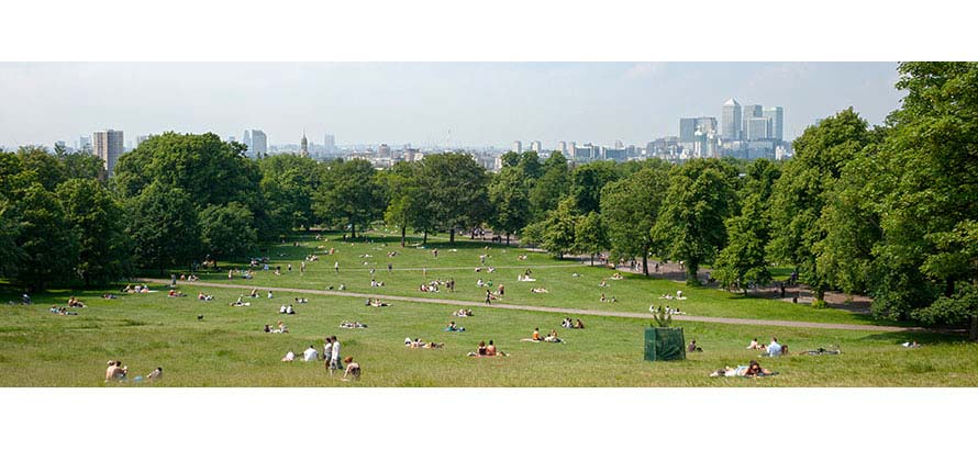People relaxing in Greenwich Park on a sunny spring afternoon.