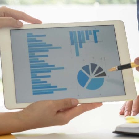 Man pointing at analytics on a tablet