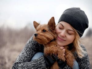 Woman cuddling her dog, they are both finally settled in their new home after a easy international move. Trusted international moving from Hong Kong, Santa Fe Relocation.