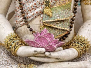 A buddha's hands hold a beautiful flower. A sacred symbol of the beautiful country of Thailand, one of the top destinations for international moving at Santa Fe Relocation.